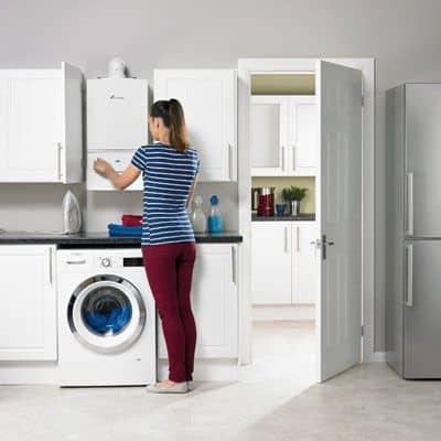 Woman in utility room fitted with gas boiler in Wrexham