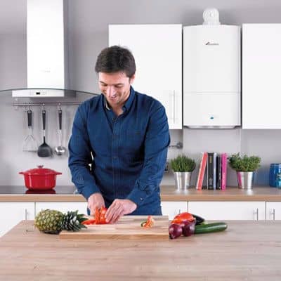 Man in kitchen in Wrexham next to gas boiler